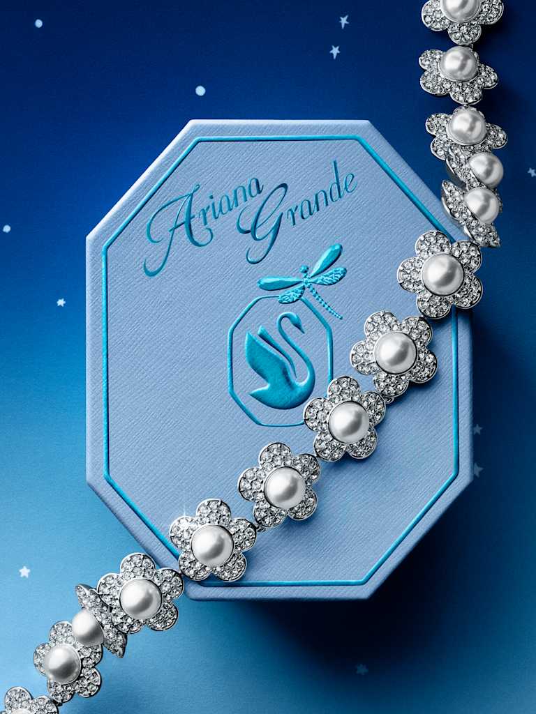 Pearl and crystal Swarovski bracelet beside a blue Ariana Grande x Swarovski gift box.