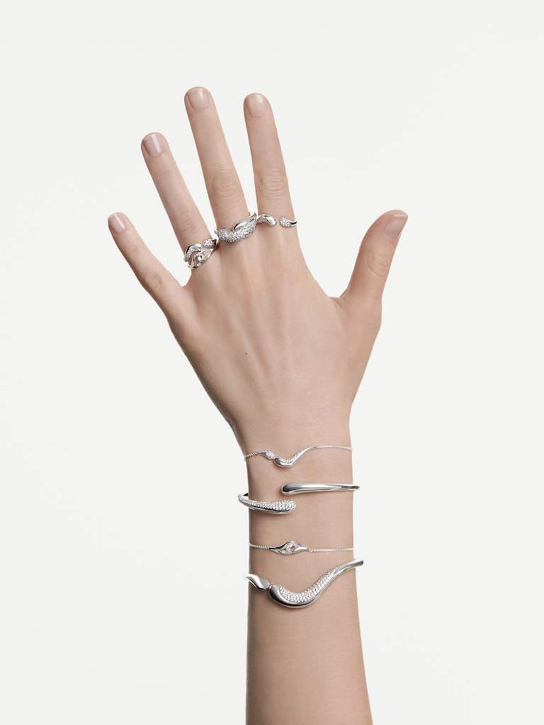 Combinación de pulseras plateadas en la muñeca al estilo Swarovski