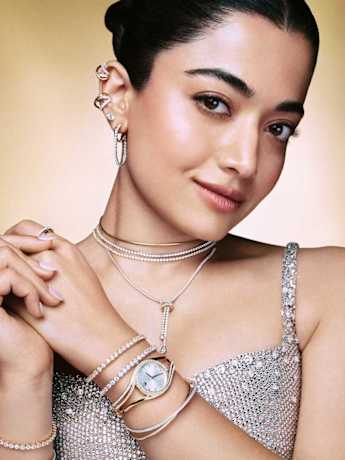 Female model in sparkling top wearing layered Swarovski Hyperbola jewelry.