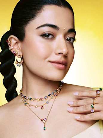 Female model in yellow sari wearing Swarovski multicoloured layered jewellery. 