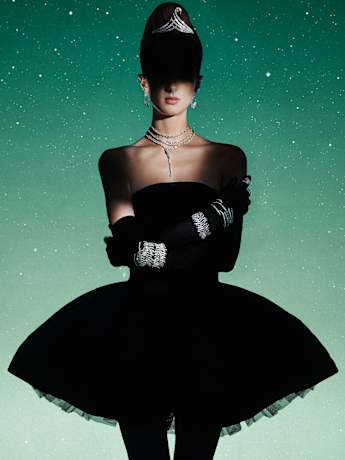 Female model in black dress and gloves wearing Swarovski Viena collection jewelry.