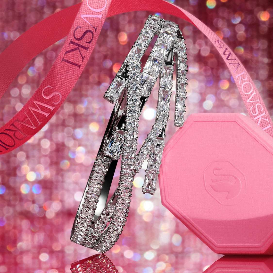 Náramky Swarovski a růžová dárková krabička na růžovém pozadí
