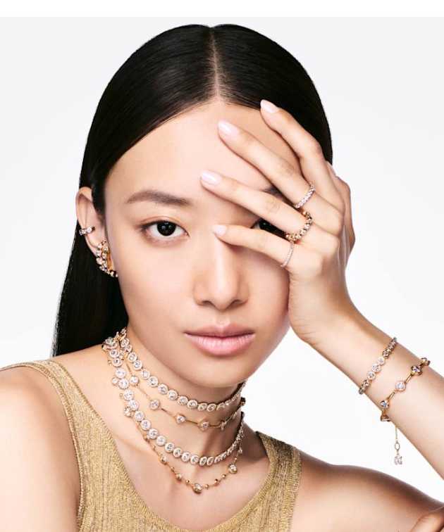 Modelka ozdobená náramky a prsteny Swarovski