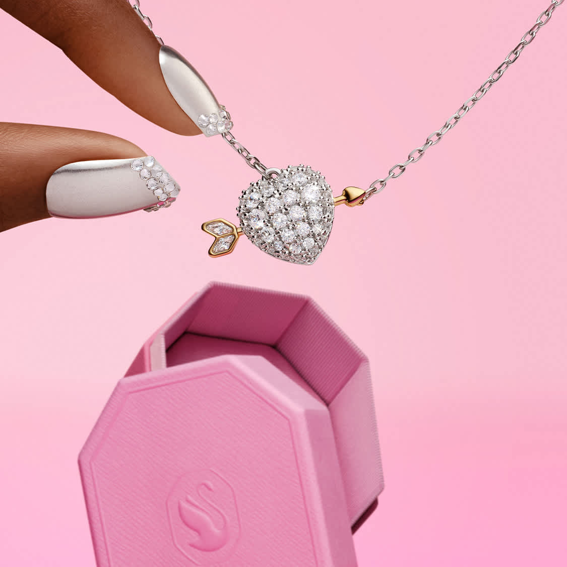 Palce sięgające po wisiorek w kształcie serca