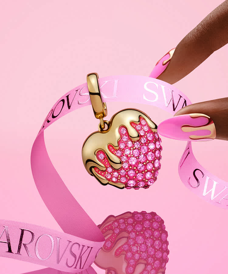 Prsty sahající po přívěsku Swarovski v podobě jahody