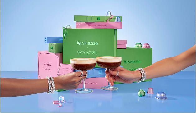 Dwie ręce modelki w biżuterii Swarovski trzymające szklankę kawy Nespresso