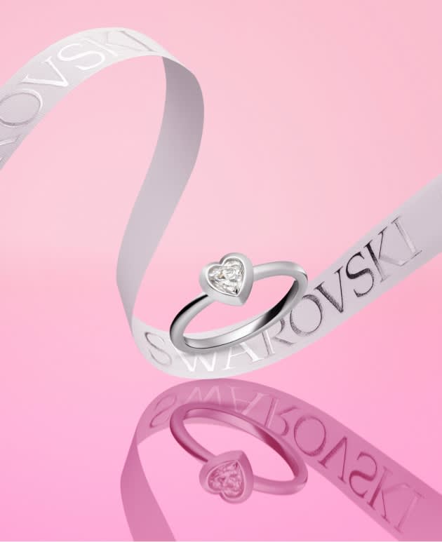 Swarovski Created Diamond Ring and a white ribbon on a pink background